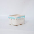 Storage basket with decorative pom-pom trim