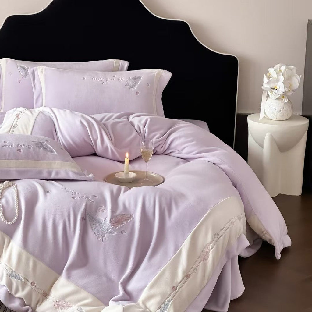 Luxurious bedding set with embroidered feather motifs and quilted bedspread