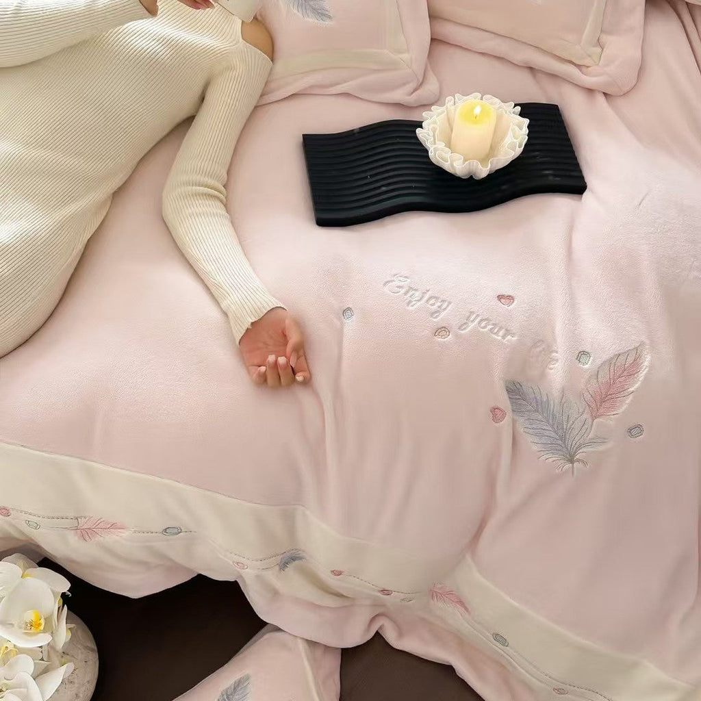 Luxurious bedding set with embroidered feather motifs and quilted bedspread