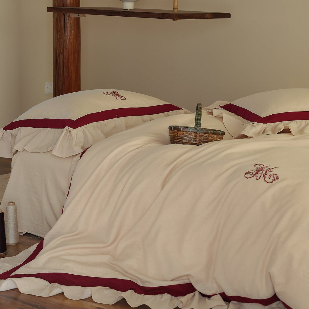 Romantic cotton-linen bedding set with ruffle, monogram embroidery, and contrasting trim Bowlift