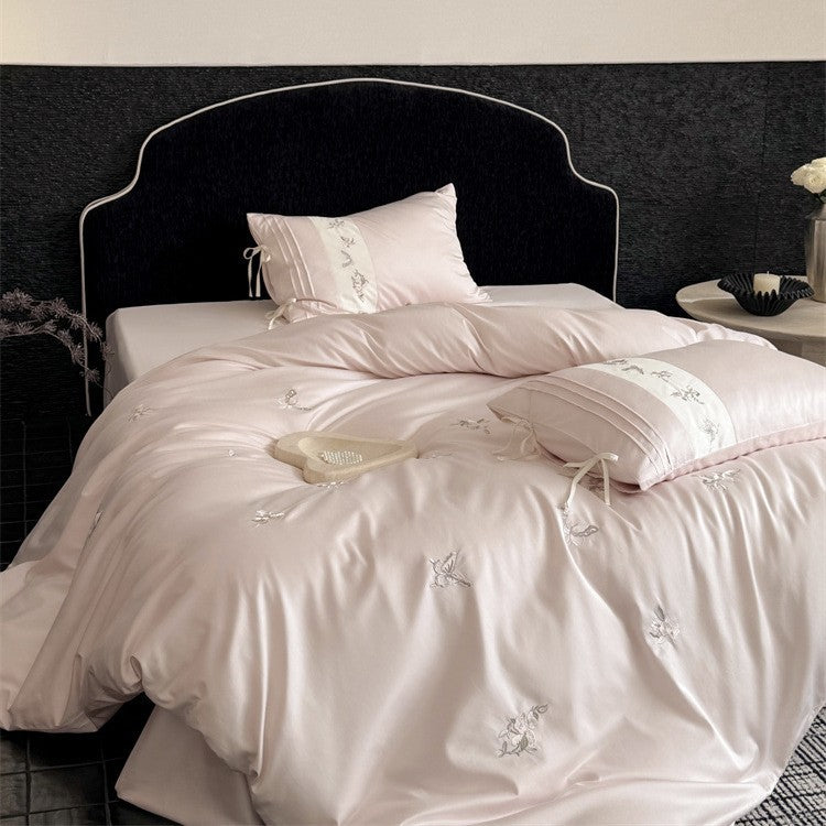 Luxurious satin bedding set with embroidered floral appliqués and bolster Bowlift