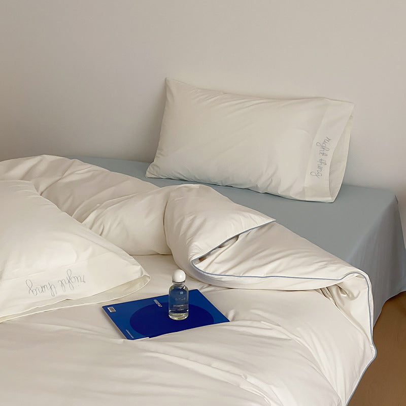 Cotton satin bed linen set with contrasting piping and subtle brand embroidery