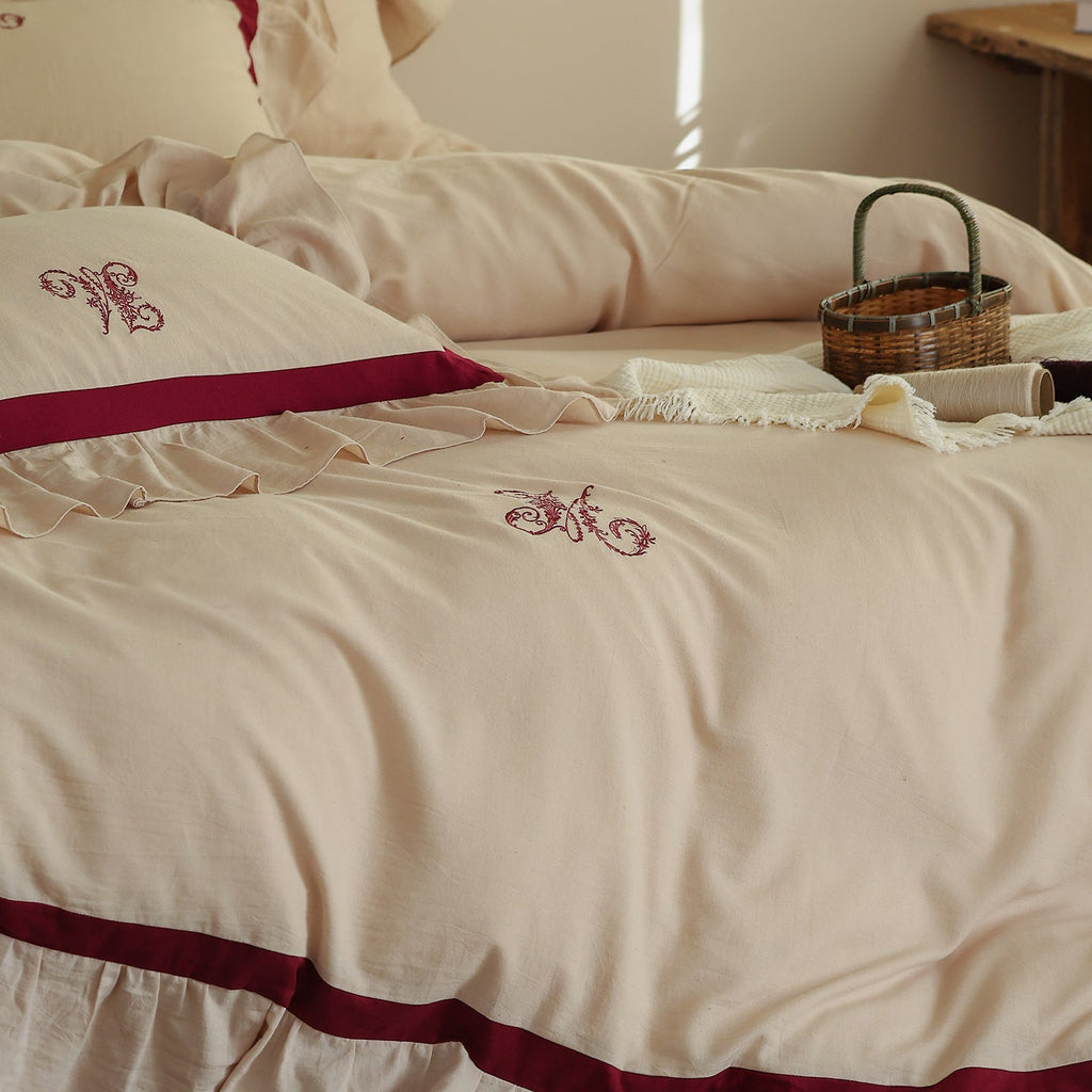 Romantic cotton-linen bedding set with ruffle, monogram embroidery, and contrasting trim Bowlift
