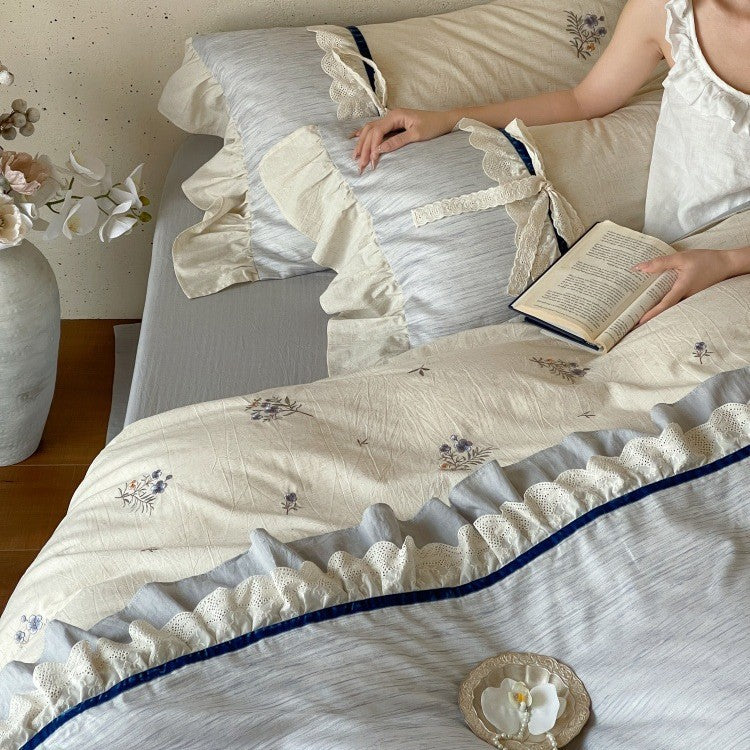 Romantic cotton satin bedding set with ruffles, embroidered flower bouquets, and decorative rolls Bowlift
