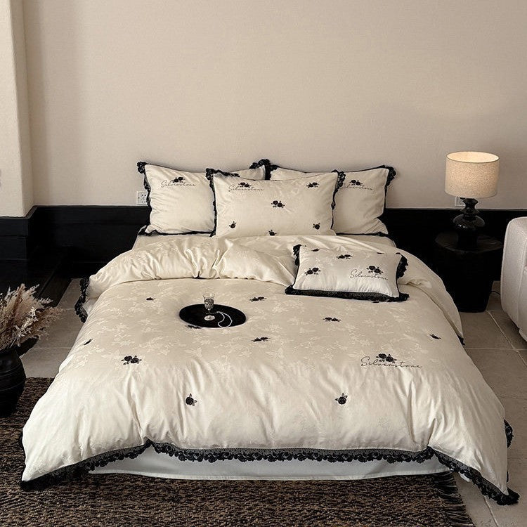 Luxurious satin bedding set with black lace trim and embroidered rose appliqués