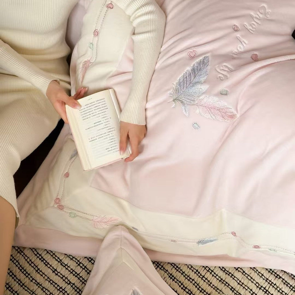 Luxurious bedding set with embroidered feather motifs and quilted bedspread