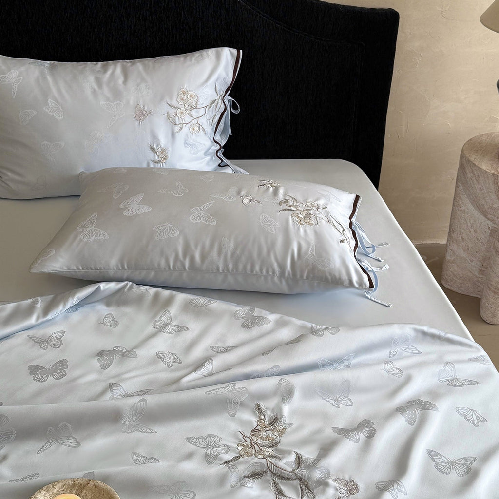 Light jacquard satin bed linen set with embroidered butterfly motif and decorative roll Bowlift