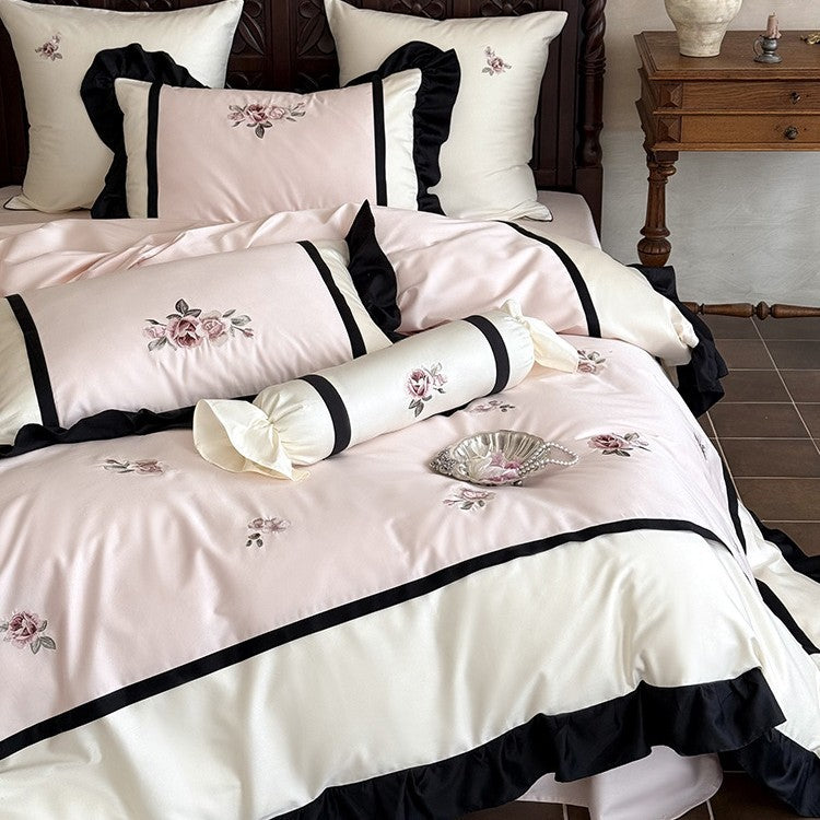 Luxurious embroidered bed linen set made of cotton satin with ruffles and decorative pillows