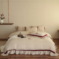 Romantic cotton-linen bedding set with ruffle, monogram embroidery, and contrasting trim Bowlift