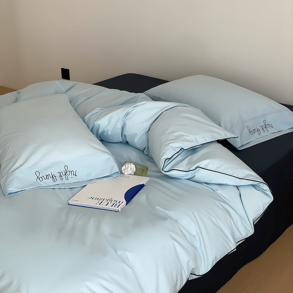 Cotton satin bed linen set with contrasting piping and subtle brand embroidery