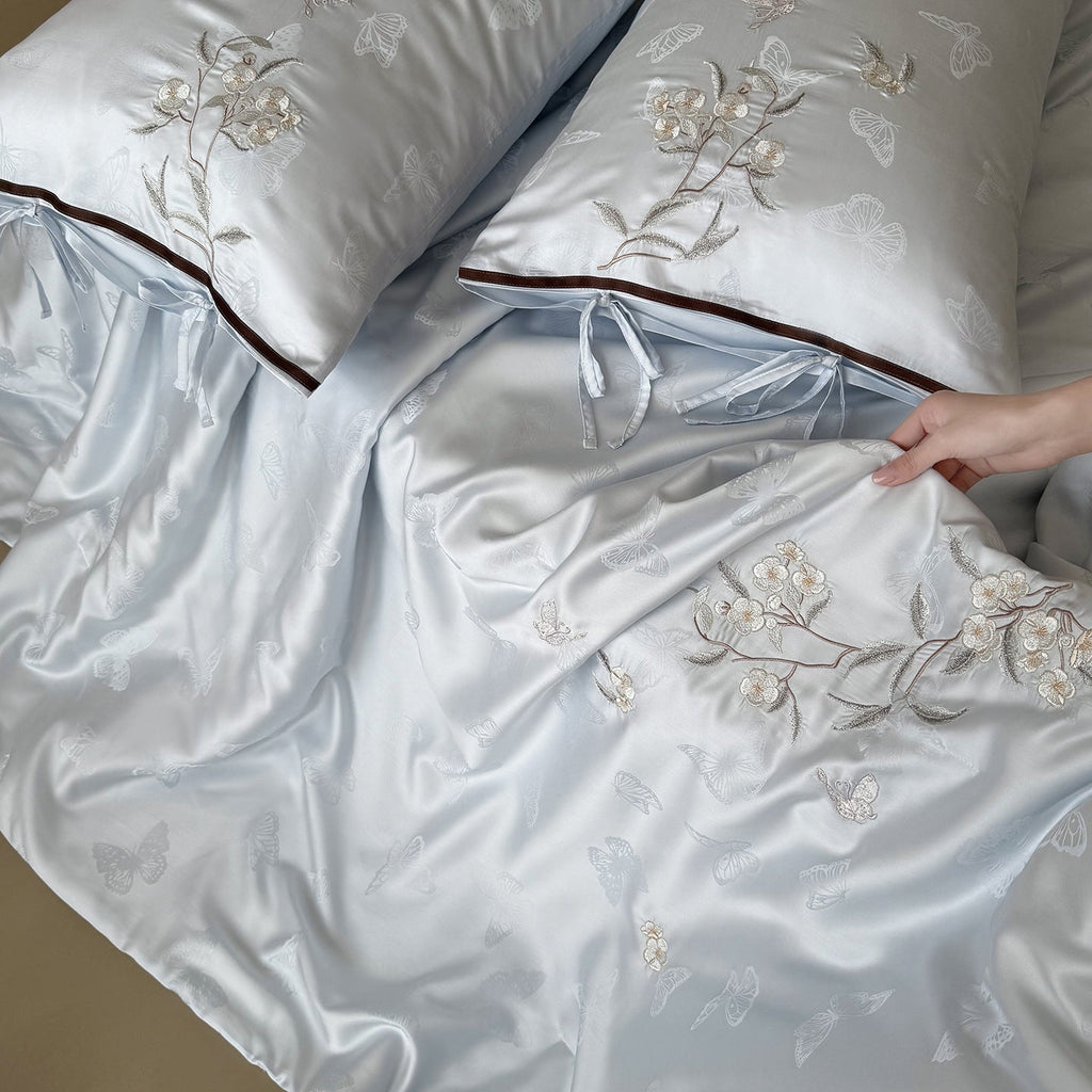 Light jacquard satin bed linen set with embroidered butterfly motif and decorative roll Bowlift