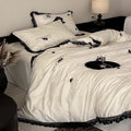 Luxurious satin bedding set with black lace trim and embroidered rose appliqués