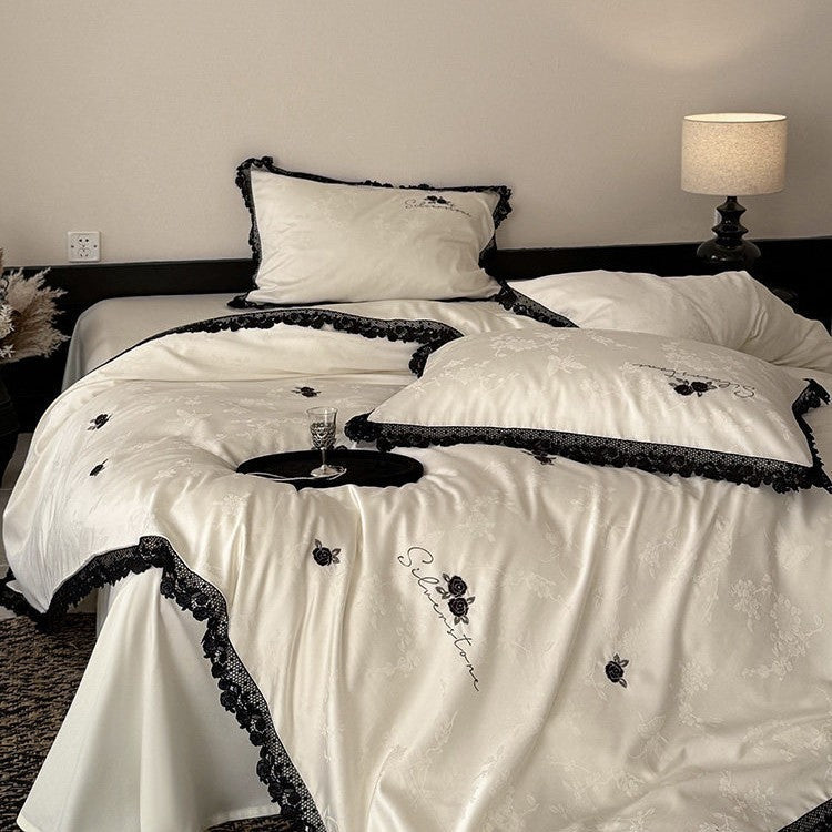 Luxurious satin bedding set with black lace trim and embroidered rose appliqués